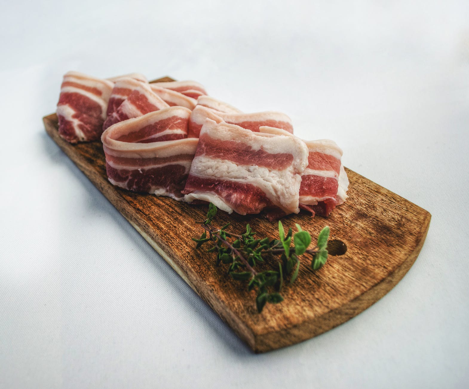 food photography of sliced bacon on top of brown chopping board